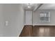 Bright living room featuring dark wood floors, a window, and a classic white door at 4252 Rockdell Hall St, Raleigh, NC 27616
