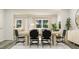 A bright dining area features a long table and black chairs, connecting seamlessly to a comfortable living space at 472 Carolina Springs Blvd, Apex, NC 27539