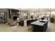 Open-concept living room and kitchen with modern furniture, stylish decor, and plenty of natural light from surrounding windows at 472 Carolina Springs Blvd, Apex, NC 27539