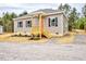 Charming single-story home featuring a welcoming front porch and neutral siding with black shutters at 48 S Grace Way, Henderson, NC 27537