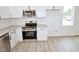 Modern kitchen featuring stainless steel appliances, granite countertops, and white cabinetry for ample storage space at 48 S Grace Way, Henderson, NC 27537