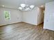Open living area with light wood flooring, a contemporary light fixture, and a view of the entryway at 48 S Grace Way, Henderson, NC 27537