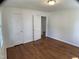 A bright bedroom with hardwood floors, a window, and access doors at 509 Coleman St, Raleigh, NC 27610