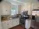 Bright kitchen with stainless steel appliances, white cabinetry, and granite countertops at 509 Coleman St, Raleigh, NC 27610