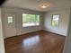 Empty living room showcasing hardwood flooring and natural light from the windows at 509 Coleman St, Raleigh, NC 27610