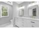 Bright bathroom with double sink vanity, marble countertops, gold fixtures and mirrors at 5301 Night Heron Dr, Wake Forest, NC 27587