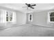 Large bedroom with neutral walls and carpet, ceiling fan, and three windows letting in natural light at 5301 Night Heron Dr, Wake Forest, NC 27587