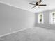 Spacious bedroom with neutral carpet, ceiling fan, two windows, and white trim at 5301 Night Heron Dr, Wake Forest, NC 27587