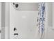 Bright white shower with black fixtures and blue-and-green floral shower curtain at 5301 Night Heron Dr, Wake Forest, NC 27587