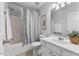Well-lit bathroom with shower-tub combo, white vanity, toilet, and patterned shower curtain at 5318 Crescentview Pkwy, Raleigh, NC 27606