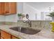 Close-up of the kitchen sink with granite countertops and wood cabinets at 5318 Crescentview Pkwy, Raleigh, NC 27606