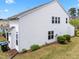 View of the home's rear, featuring white siding, well-kept lawn, and mature landscaping at 5518 Jessip St, Morrisville, NC 27560