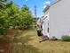 Backyard area showcasing the home's siding, green lawn, and privacy trees at 5518 Jessip St, Morrisville, NC 27560