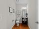 Cozy half-bathroom with wood floors, pedestal sink, decorative mirror, and artwork at 5518 Jessip St, Morrisville, NC 27560