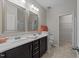 Well-lit bathroom with double sinks, dark cabinetry, and tiled flooring at 5518 Jessip St, Morrisville, NC 27560