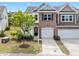 Charming townhome with stone facade and attached garage, complemented by a well-manicured lawn and young tree at 5518 Jessip St, Morrisville, NC 27560