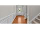 Bright foyer with hardwood floors, wainscoting, a glass-paneled door, and staircase leading upstairs at 5518 Jessip St, Morrisville, NC 27560