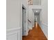 Hallway with hardwood floors and traditional wainscoting leading to a staircase and rooms at 5518 Jessip St, Morrisville, NC 27560