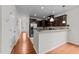 Kitchen with stainless steel refrigerator, dark cabinets, granite counter and hardwood floors leading to the foyer at 5518 Jessip St, Morrisville, NC 27560