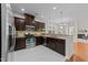 Modern kitchen featuring dark wood cabinets, granite countertops, stainless steel appliances, and marble flooring at 5518 Jessip St, Morrisville, NC 27560