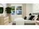 Sunlit bedroom with a large window, wood dresser, and modern black and white decor at 613 Cassa Clubhouse Way, Knightdale, NC 27545