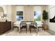 Formal dining room features a modern chandelier and natural light from large windows at 615 Cassa Clubhouse Way, Knightdale, NC 27545