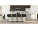Bright kitchen features granite counters, stainless appliances, dark cabinets and a seating area at 615 Cassa Clubhouse Way, Knightdale, NC 27545