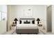 This bedroom offers a soothing palette, a comfy queen bed, & two bedside tables with lamps at 617 Cassa Clubhouse Way, Knightdale, NC 27545