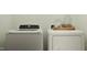 Bright laundry room features white appliances and decorative jars on a wooden tray at 617 Cassa Clubhouse Way, Knightdale, NC 27545