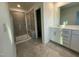 Bathroom with tiled walk-in shower and a double sink vanity with white cabinets and granite countertop at 621 Cassa Clubhouse Way, Knightdale, NC 27545