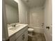 Bathroom featuring white vanity, toilet, and shower/tub combo with vinyl surround and bronze hardware at 621 Cassa Clubhouse Way, Knightdale, NC 27545