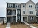 New townhomes boasting gray and blue siding, stone accents, covered entries, and landscaped yards at 621 Cassa Clubhouse Way, Knightdale, NC 27545
