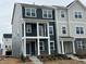 Modern townhome featuring dark blue and gray siding, white trim, a small balcony and a well-manicured lawn at 621 Cassa Clubhouse Way, Knightdale, NC 27545