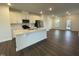 Bright, open kitchen featuring white cabinets, stainless steel appliances, and a spacious central island at 621 Cassa Clubhouse Way, Knightdale, NC 27545