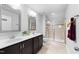 Modern bathroom with dual sinks, granite countertop, a tiled shower, and well-lit vanity lights at 6230 Pesta Ct, Raleigh, NC 27612