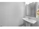 Clean half bath with modern pedestal sink, sleek mirror, and neutral color scheme at 6230 Pesta Ct, Raleigh, NC 27612