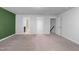 Spacious bedroom featuring neutral carpet, a green accent wall, and multiple entryways for seamless navigation at 6230 Pesta Ct, Raleigh, NC 27612