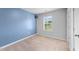 Bedroom with plush carpet, blue accent wall, and lots of natural light at 6230 Pesta Ct, Raleigh, NC 27612