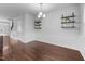Open dining room with stylish wood flooring, elegant lighting, wainscoting detail and decorative shelving at 6230 Pesta Ct, Raleigh, NC 27612