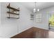 Bright dining room with wainscoting, hardwood floors, decorative shelving and chandelier at 6230 Pesta Ct, Raleigh, NC 27612
