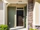 Close-up of home's front door showing dark wood finish, stone accents, and a well-kept lawn at 6230 Pesta Ct, Raleigh, NC 27612