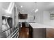 Open concept kitchen featuring stainless steel appliances, dark wood cabinets, and spacious island with granite countertops at 6230 Pesta Ct, Raleigh, NC 27612