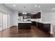 Modern kitchen with stainless steel appliances, dark cabinetry, and large center island with quartz countertops at 6230 Pesta Ct, Raleigh, NC 27612