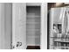 Walk-in pantry featuring white wire shelving and an open door next to stainless steel refrigerator at 6230 Pesta Ct, Raleigh, NC 27612