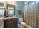 Well-lit bathroom featuring a vanity with a granite countertop, decorative mirror, and shower with patterned curtain at 658 Bennett Mountain Trce, Chapel Hill, NC 27516