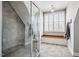 Modern bathroom featuring tiled walls, glass enclosed shower, and bench seating by window at 658 Bennett Mountain Trce, Chapel Hill, NC 27516