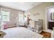 Light-filled Bedroom with hardwood floors, crib, chair, and decorative wall art at 658 Bennett Mountain Trce, Chapel Hill, NC 27516