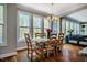 Sunlit dining area showcases a wood table set for six, hardwood flooring and a decorative chandelier at 658 Bennett Mountain Trce, Chapel Hill, NC 27516