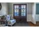 Inviting foyer featuring double front doors with shutters, a comfortable chair, and a patterned rug at 658 Bennett Mountain Trce, Chapel Hill, NC 27516