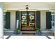 Elegant double front doors flanked by dark shutters, hanging plants, and a welcome sign at 658 Bennett Mountain Trce, Chapel Hill, NC 27516